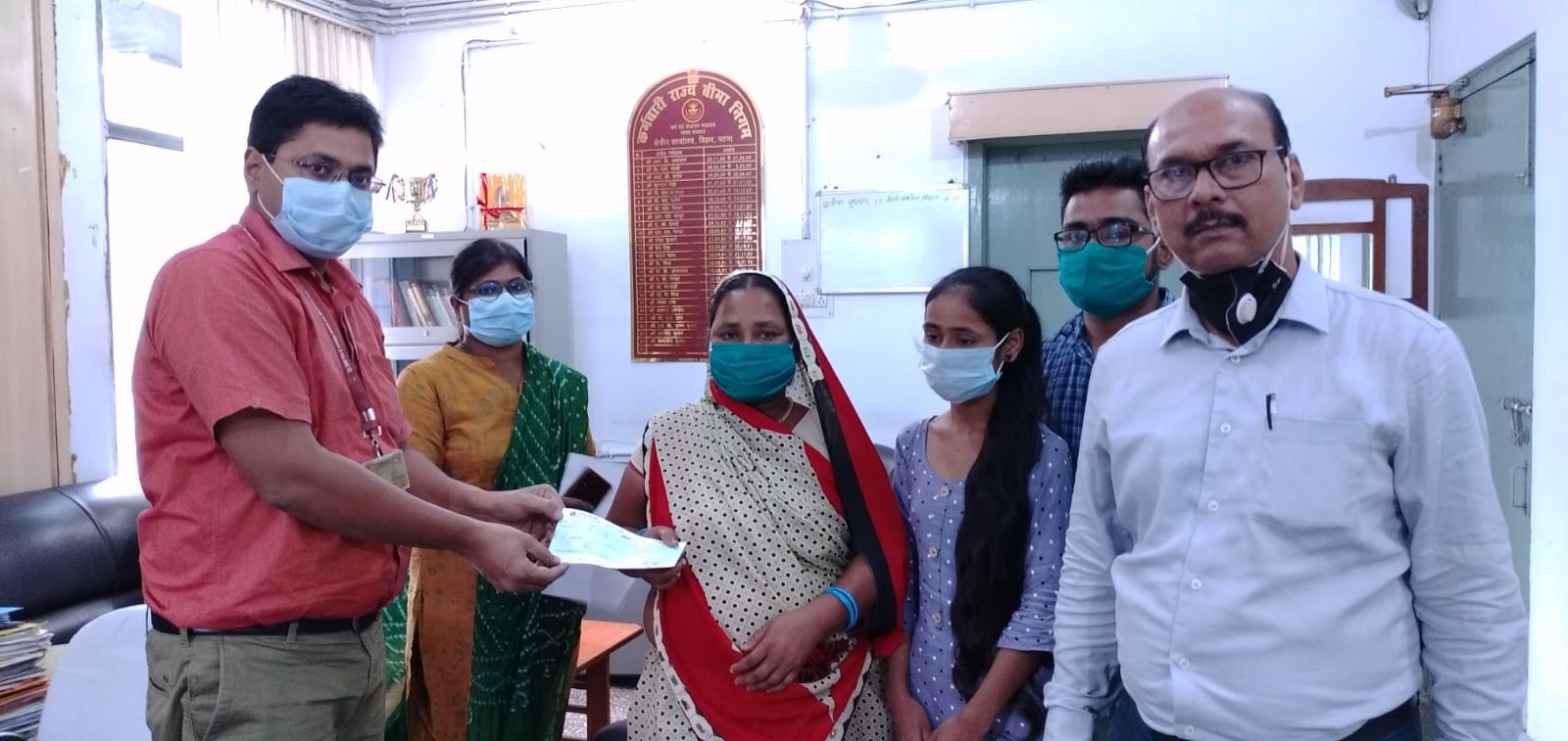 क्षेत्रीय निदेशक द्वारा बीमित के आश्रितों को हितलाभ का चेक प्रदान करते हुए